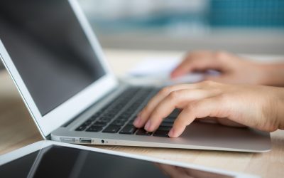 Closeup of business woman hand typing on laptop keyboard